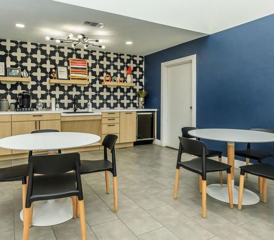 a kitchen with blue walls and black and white tile at The Orbit Apartments
