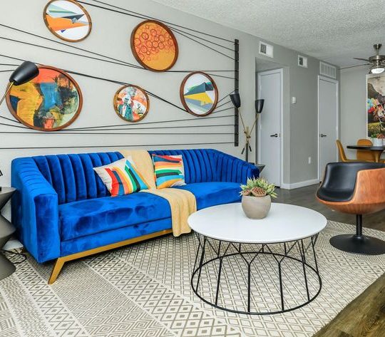 a living room with blue couches and a coffee table at The Orbit Apartments